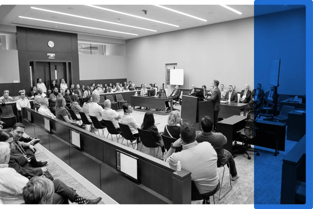 A courtroom filled with people listening to a technology demonstration